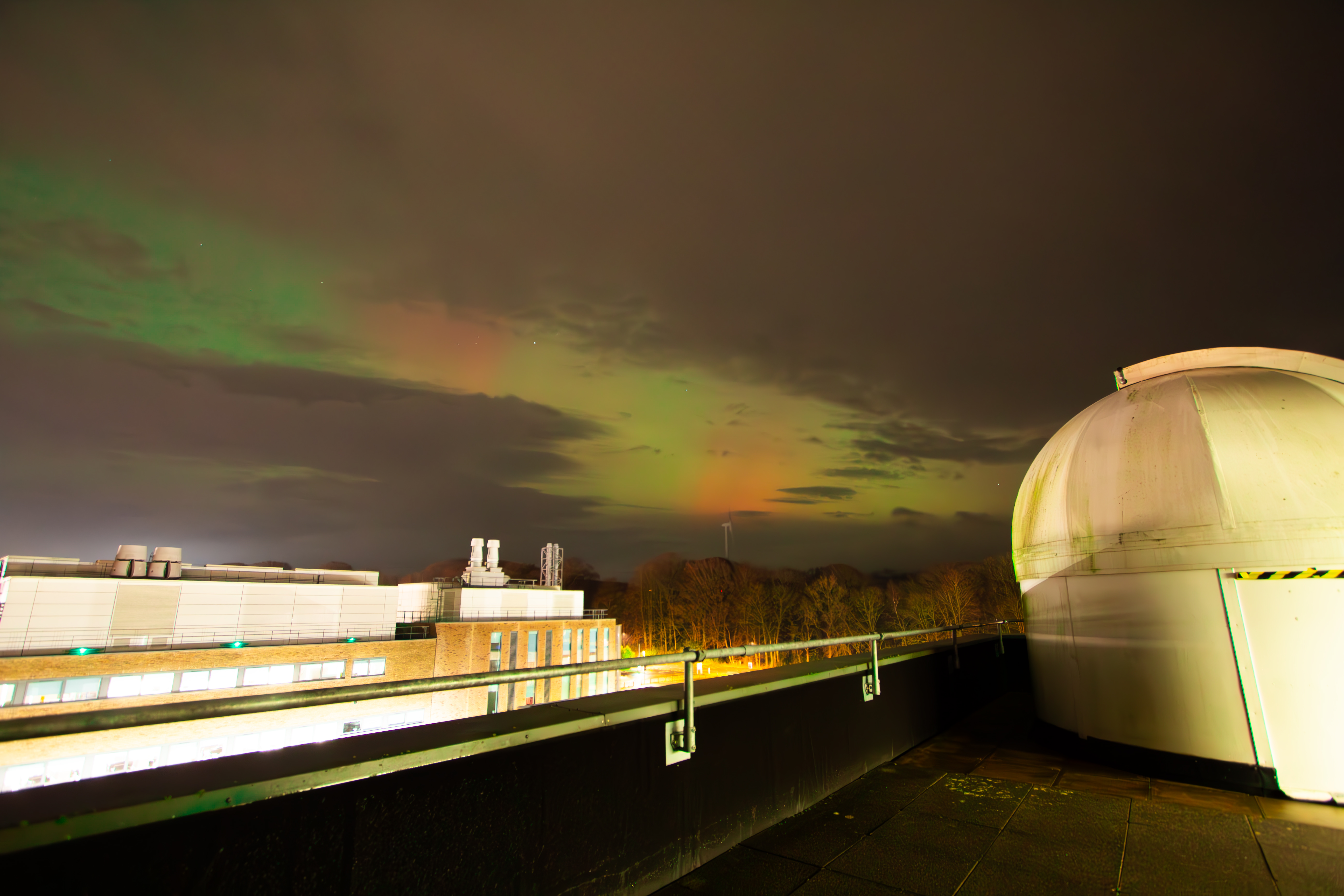 The Northern Lights, between the clouds, as viewed from the roof of the Physics Building. Taken by Leo O'Hara.